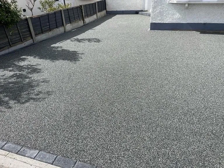 The same bungalow with a silver-grey resin bound driveway and charcoal block edging